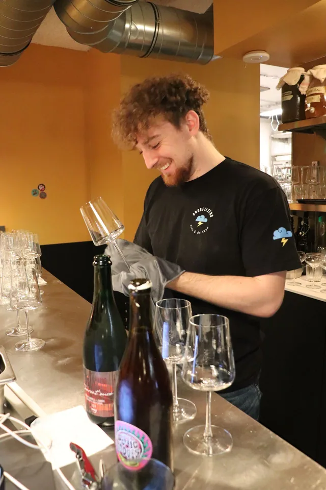 Een fles wordt ontkurkt achter de toog